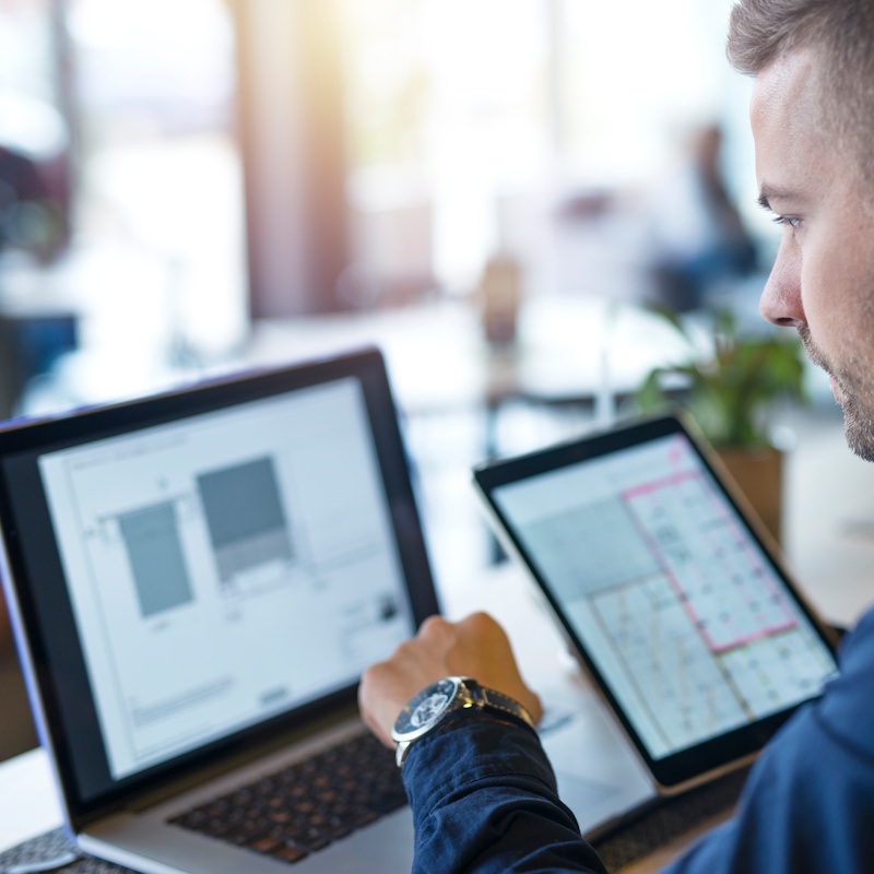 Homme travaillant sur ordinateur et tablette